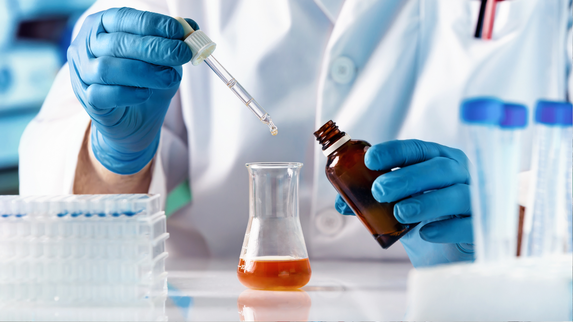 Lab technician using a dropper to test water chemistry in support of alkalinity control in water treatment systems