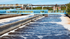 Industrial basin showing active treatment where a chemical dispersant is used to break surface contaminants and maintain water column clarity.