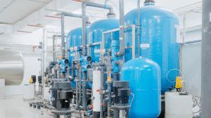 Industrial water treatment system with blue tanks and pumps showing monitoring systems and chemical control in operation