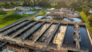 Aerial view of a potable water treatment plant at sunset, showing sedimentation and filtration basins.