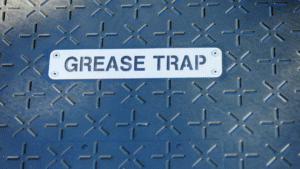 Metal cover labeled grease trap representing wastewater management system access point.
