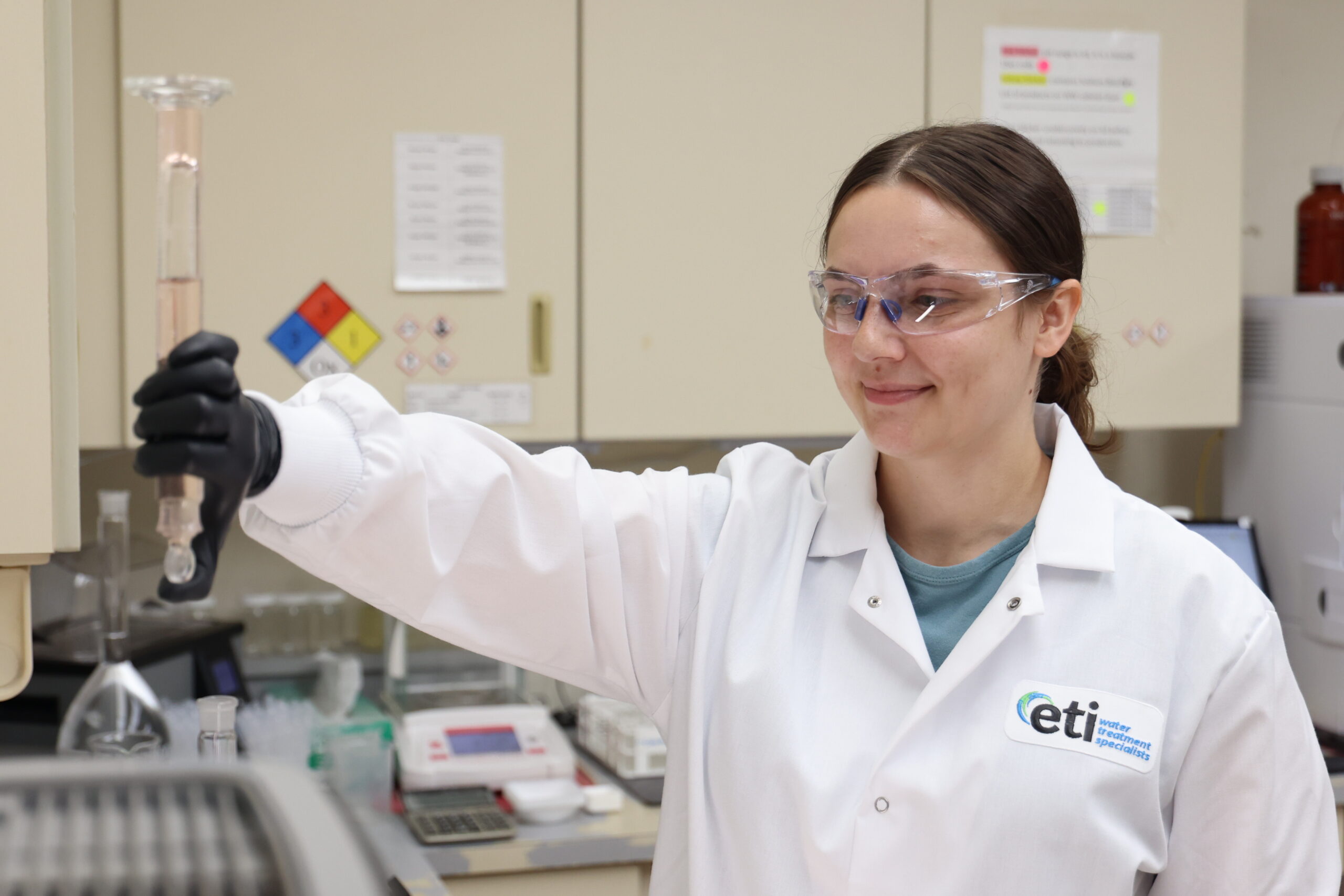 ETI lab technician measuring samples to monitor microbial growth in water systems.