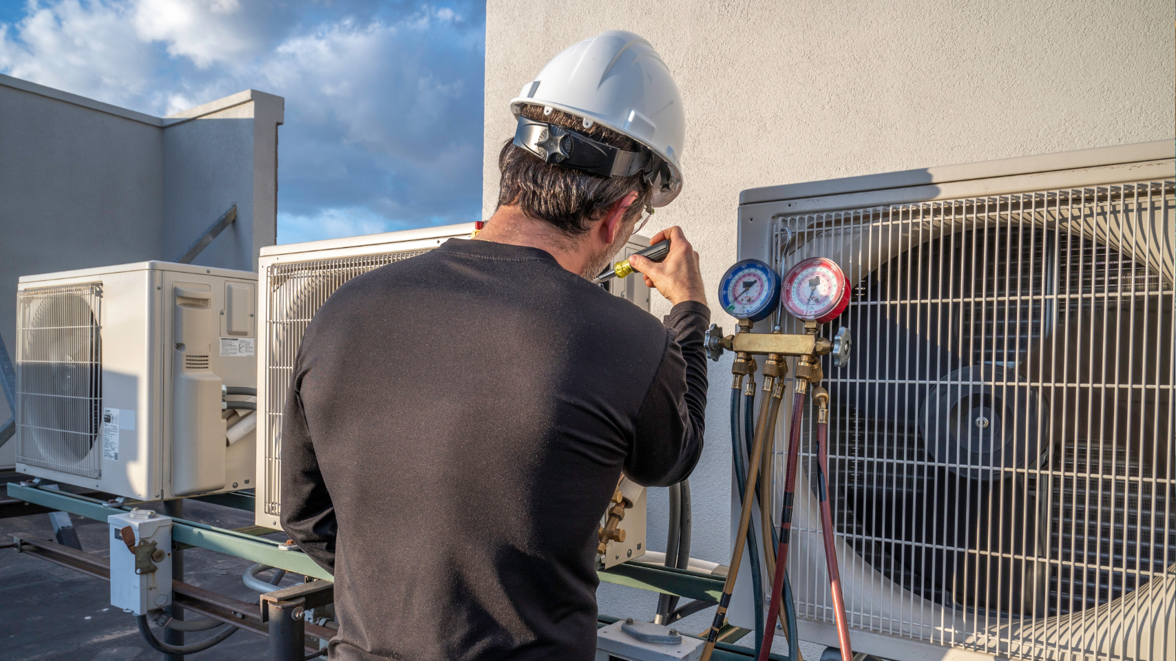 Technician inspecting rooftop HVAC unit as part of closed loop water treatment program to protect heat exchangers and system efficiency