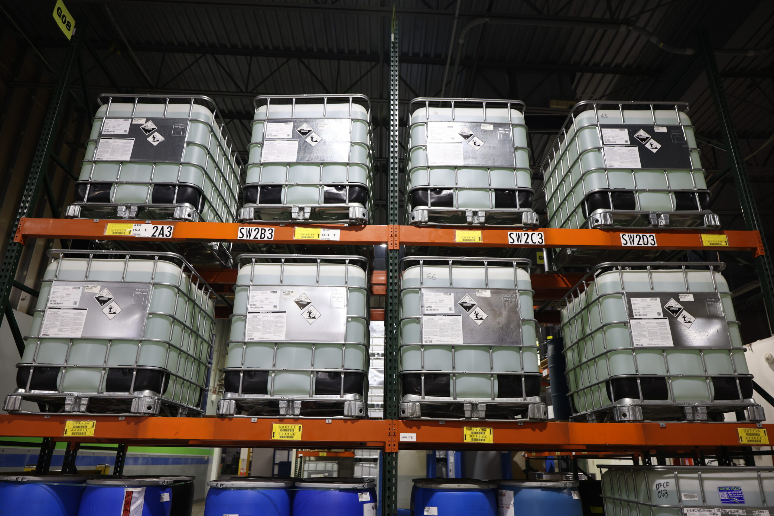 Chemical labeling on hazardous material containers stored in an industrial warehouse