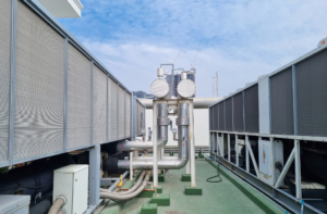 Commercial rooftop cooling equipment and piping associated with industrial water-system operation and Legionella biofilm risk.