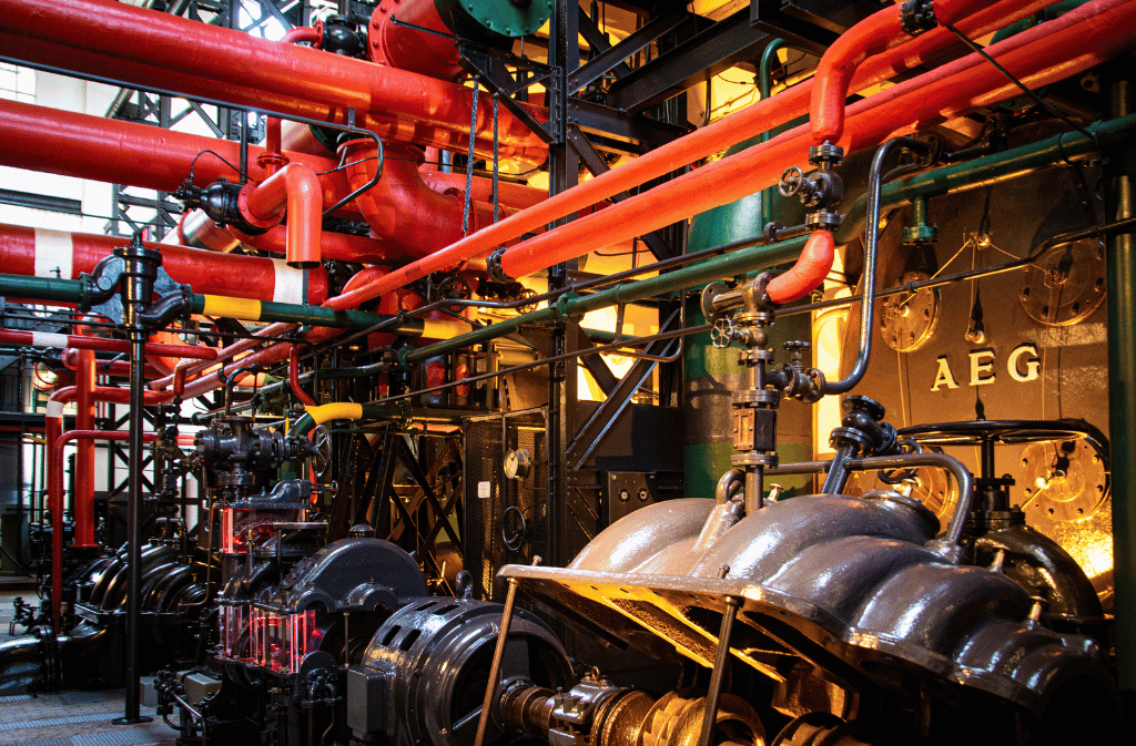 Industrial machinery room with interconnected piping and control valves.