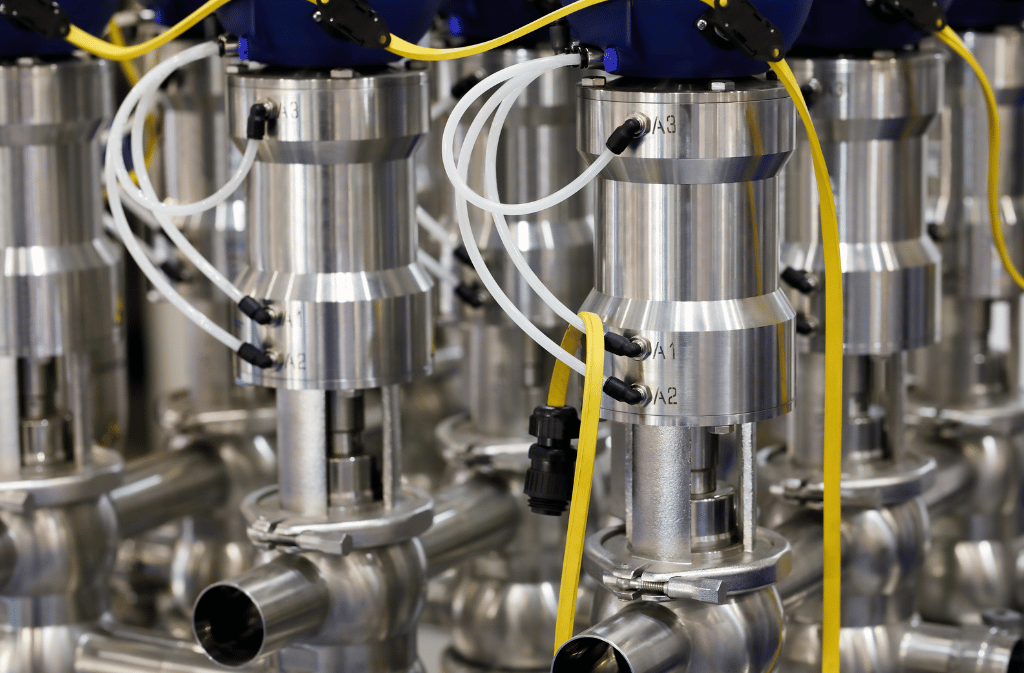 Automated industrial valve assemblies with connected tubing and wiring.