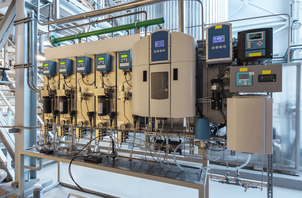 Industrial water monitoring panel with analyzers, sample tubing, and flow controls.
